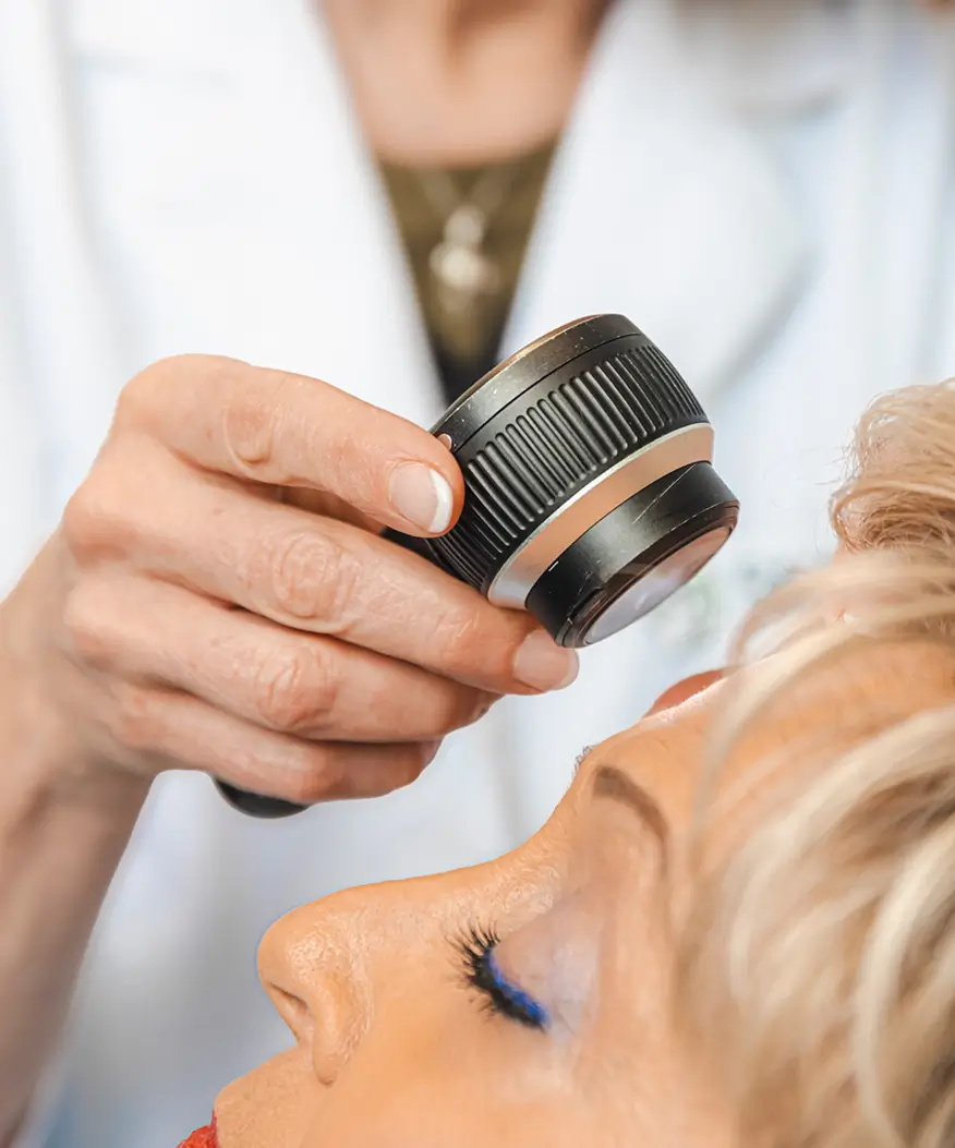 Dermatologist examining a patient's face