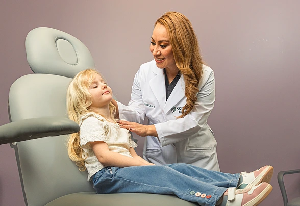 Dermatologist examining a smiling young patient